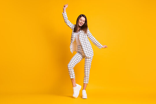 Full Length Body Size Photo Of Dancing Girl Wearing White Checkered Formal Wear Smiling Isolated On Bright Yellow Color Background