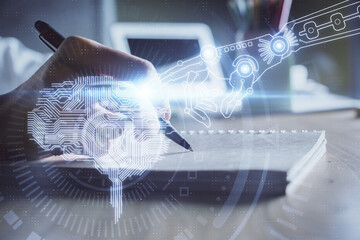 Multi exposure of writing hand on background with brain hologram. Concept of self learning.