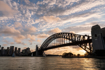 Sydney Harbour Bridget at sunset with golden light in the background and clouds in the sky