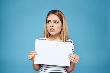 Naklejka premium Emotional woman holding a sheet of paper in her hands lifestyle close-up blue background Copy Space