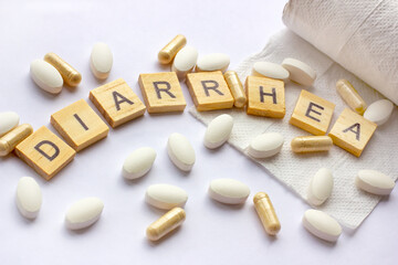 The medical phrase diarrhea on pills, capsules and tablets with toilet paper on light background. Pharmacy theme, health care, drug prescription for treatment medication and medicament.