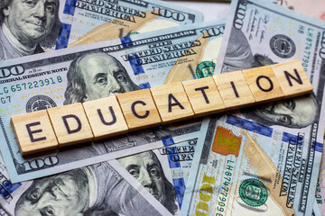 The word education on dollar usa background. College credits, graduation funds, tuition money concept. - 387113350