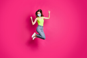 Full body photo of excited young girl celebrate jump up wearing blue face mask isolated over pink color background