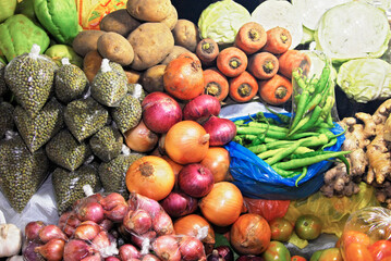 Mixed colorful vegetables and spices, partially wrapped in plastic, nicely presented at a local farmers market in the Philippines, Asia