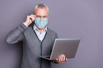 Portrait of business shark wearing casual formal-wear mask using netbook browsing isolated over gray pastel background