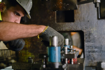 Engineer worker is repairing drill machine with metal wrench in industrial manufacturing