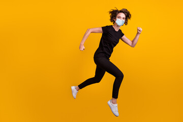 Fototapeta na wymiar Full length body photo of girl jumping running shopping center use medical mask isolated yellow color background