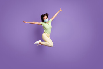 Full length view of funky cheerful girl jumping having fun flying wear mask isolated bright lilac violet color background