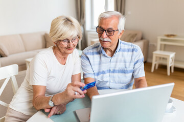 Senior Couple Using Laptop To Shop Online. Elderly couple paying bills online on laptop