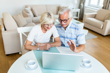 Senior couple is talking online via video connection on the laptop. Having nice time withfriends and family via video call.