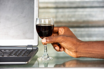 african hand holding a glass of red wine