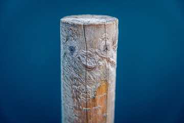 Naklejka premium Wooden column in the shape of a human face.