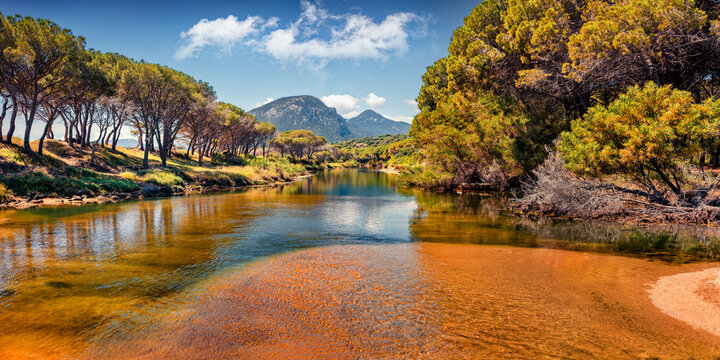 Bright summer scene of Osala Beach with Petrosu mountain on background. Sunny morning scene of Sardinia island, Italy, Europe. Beautiful seascape of Mediterranean sea.