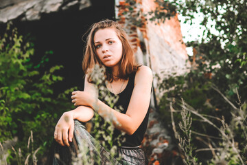 sad girl in black near abandoned old buildings