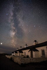 The Milky Way over Llanddwyn pilots cottages at Ynys Llanddwyn on Anglesey, North Wales.