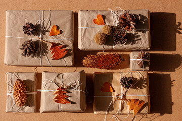 Zero waste Christmas knolling flat lay with hard shadows. Hand crafted eco gift, natural New Year jute decorations top view. Kraft paper wrapping without plastic concept. Orange zest tree,hearts,cones