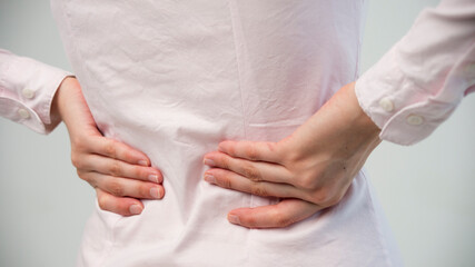 Attractive teenage girl suffers from backache. All on white background