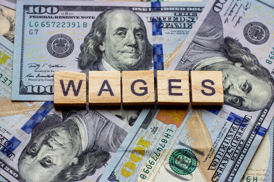 The Word Wages On Dollar Usa Background. Finance And Money Concept.