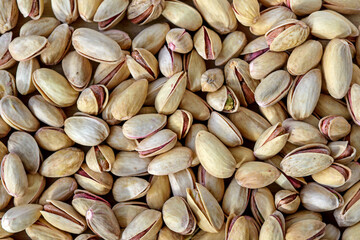 Background make from salt pistachios (into nutshells). Close up. Whole background.