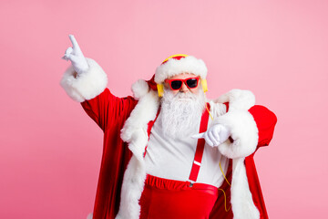 Photo of funky cool big abdomen santa claus enjoy listen headphones x-mas christmas songs radio raise fingers dance wear sunglass suspenders headwear isolated over pastel color background