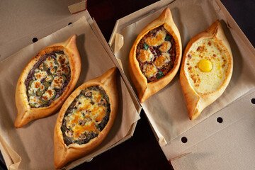 Two craft boxes with adjarian khachapuri. Food delivery concept. National Georgian dish