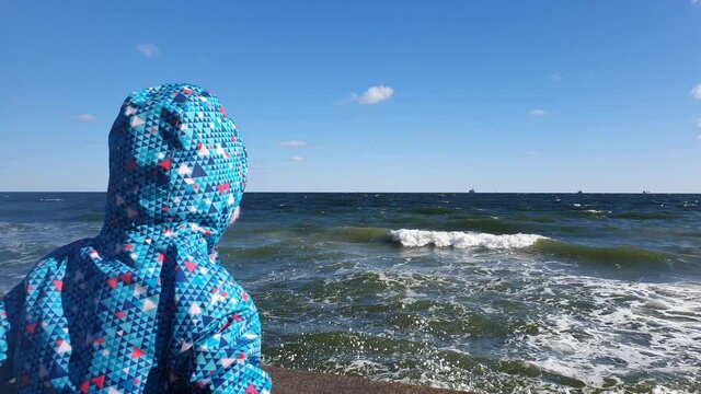 Kid looking at the sea, missing parents