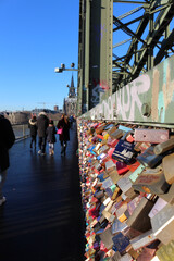 Cologne / Germany - December 30, 2019: Love Locks on the famous Hohenzollern Bridge in the city of Cologne. Cologne Cathedral is visible in the background.