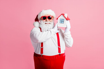 Portrait of his he nice attractive cheerful fat overweight Santa holding in hands house property insurance client service offer flat apartment purchase isolated over pink pastel color background