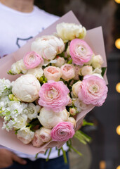 Flower shop. Beautiful bouquet of mixed flowers in woman's hands. the work of the florist at a flower shop. Delicate bright color. Fresh cut flower.