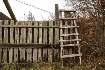 Old wooden stairs near the fence in autumn