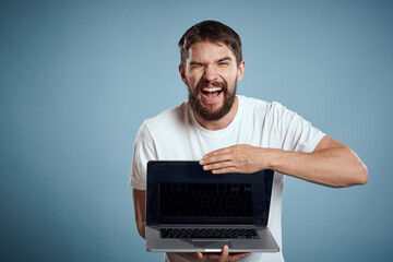 Man shows open laptop keyboard monitor emotions model blue advertising background Copy Space