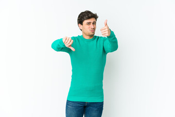 Fototapeta premium Young cool man showing thumbs up and thumbs down, difficult choose concept