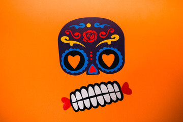 flatlay false paper photo booth props for Dia de los Muertos on orange background copyspace for Day of the dead greeting card