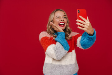 Nice caucasian happy girl winking while taking selfie on mobile phone