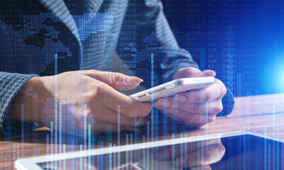 Businesswoman using mobile phone at desk