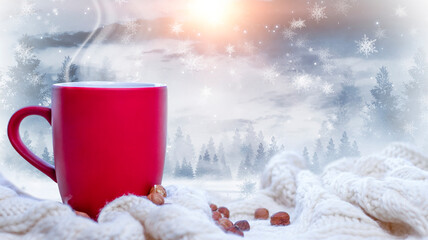 Red cup with coffee, tea on a snowy background, winter forest. A red cup against the background of a winter forest landscape on a soft, cozy scarf. Coffee, tea in the mountains.