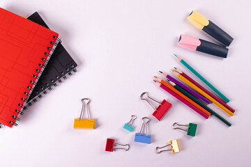 different stationary items of various colours on light surface.