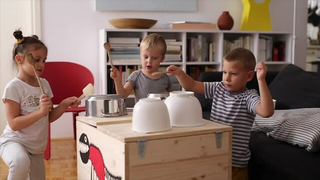 kids having fun playing on kitchen pans at home