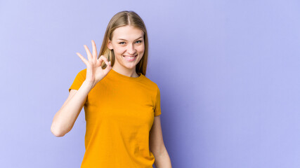 Young blonde woman isolated on purple background cheerful and confident showing ok gesture.