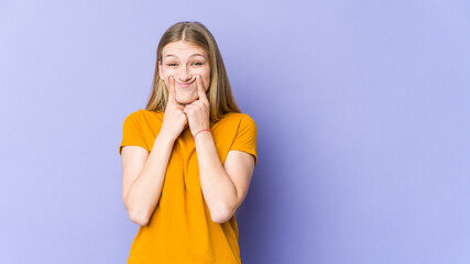 Young blonde woman isolated on purple background doubting between two options.