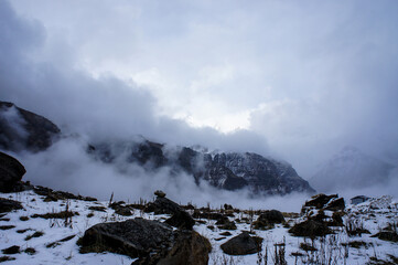 Mountain winter landscape in the cloud. Stones, rocks in the snow. Himalaya, Nepalese mountains