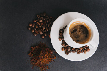cup and coffee beans on chalkboard desk background. Top view.