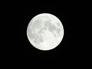 Genova, Italy - 09/25/2020: An amazing photography of the full moon over the city of Genova by night with a great clear sky in background and some stars