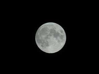 Genova, Italy - 09/25/2020: An amazing photography of the full moon over the city of Genova by night with a great clear sky in background and some stars