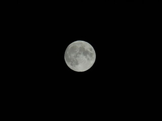 Genova, Italy - 09/25/2020: An amazing photography of the full moon over the city of Genova by night with a great clear sky in background and some stars