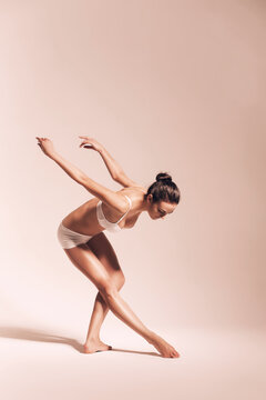 ballerina bending down in warm studio