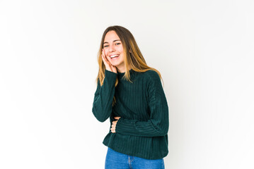 Young caucasian woman isolated on white background laughs happily and has fun keeping hands on stomach.