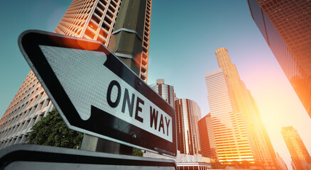 Sunrise over city skyline. Direction road sign 