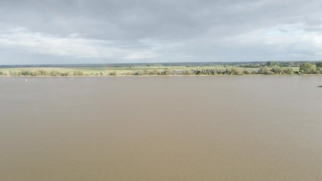 Weser mit Frachtschiff Cargo Schiff Binnenschifffahrt Elsfleth Deutschland Fluss mit Regenbogen