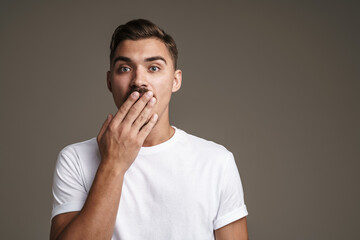 Image of shocked unshaven guy expressing surprise and covering his mouth